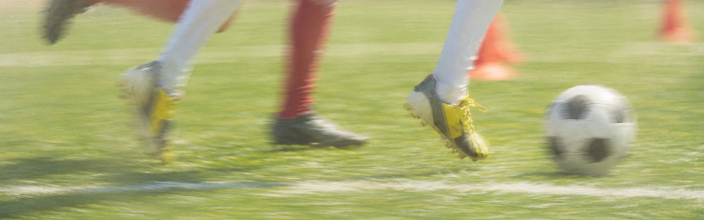 Soccer players in mid-stride on a grass field