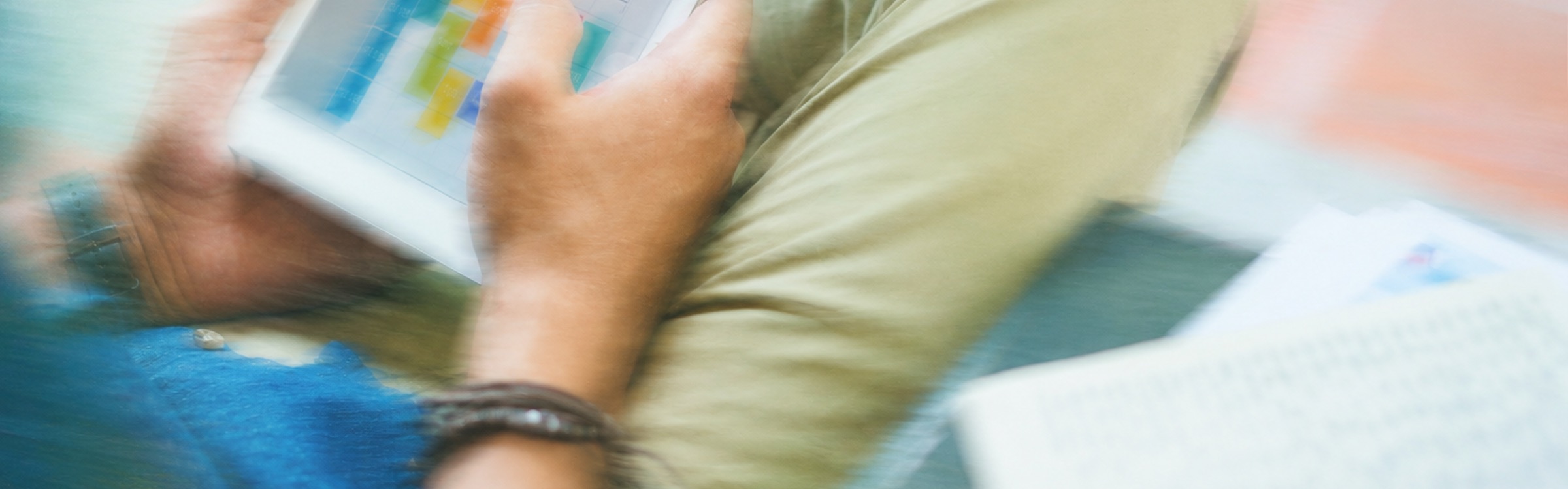 Hands holding a tablet with a colorful schedule
